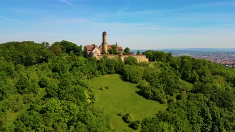4k aerial drone video of the forest surrounding the historic bamberg castle on the edge of bamberg, germany on a beautiful spring day