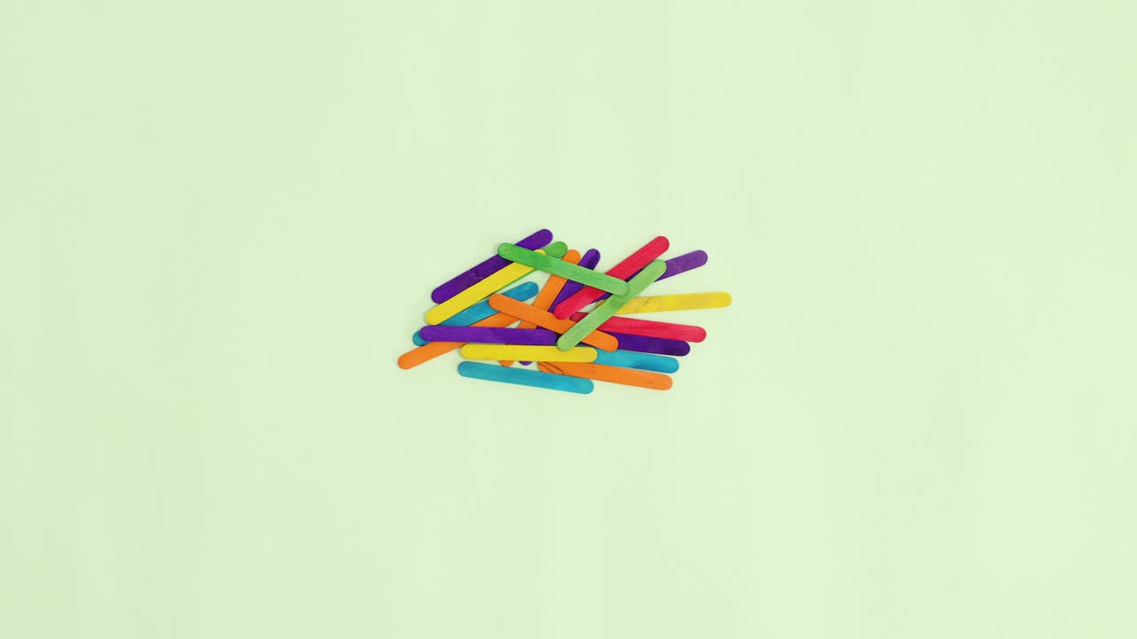 palos de madera de colores haciendo palabra de saludo en fondo verde pastel. detener la moción plana