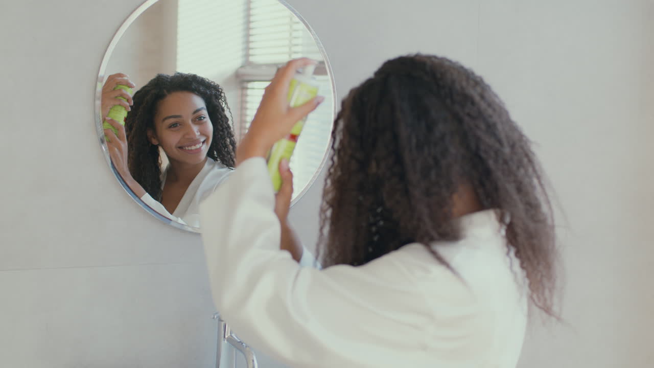 Donna che applica la lacca in bagno