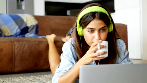 mujer usando computadora portátil mientras toma té 4k