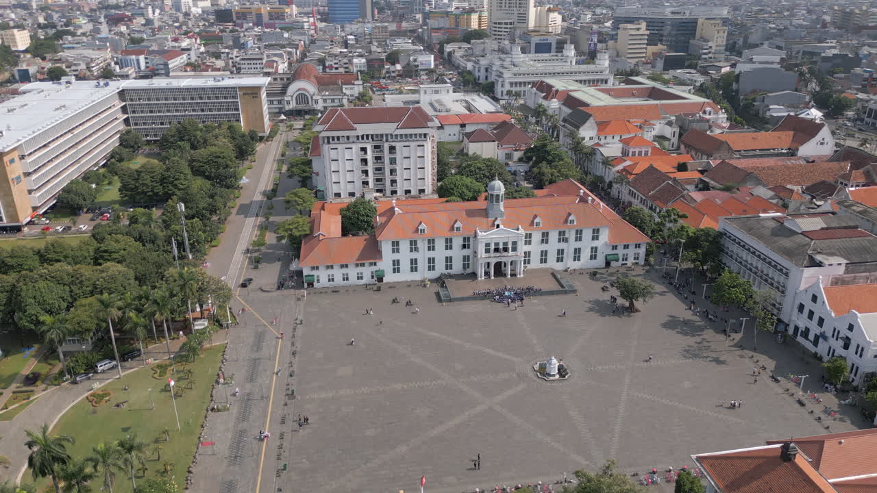 Rotação de Drone em Ângulo Elevado ao Redor da Praça Taman Fatahillah Sob o Sol da Tarde na Antiga Batávia, Jacarta