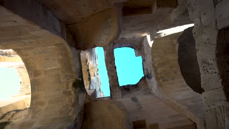 vista dentro de las ruinas del anfiteatro. la cámara está girando de abajo hacia arriba. antiguas ruinas romanas. antiguo anfiteatro ubicado en el jem, tunis. punto de referencia histórico.