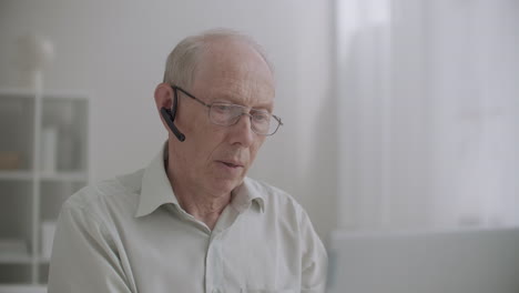 un ingeniero experimentado de edad avanzada está asesorando a los estudiantes en tecnología de videoconferencia y webinar en línea por computadora portátil
