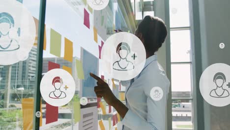 animation of network of icons over african american businesswoman in office