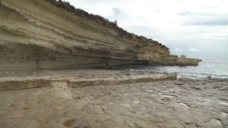 il-kalanka beach in malta with splashing water on steep limestone hill