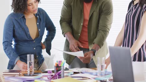 diverse male and female friends in discussion at desk, working together at home, in slow motion