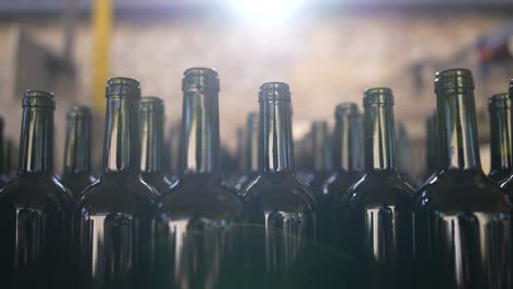 botellas de vino de vidrio verde desplazadas por una cinta transportadora en vignonet francia, toma de primer plano