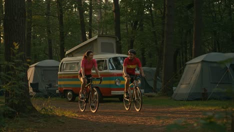 a serene camping scene featuring cyclists riding in nature near a vintage camper van in golden hour light, emphasizing outdoor adventures and tranquility