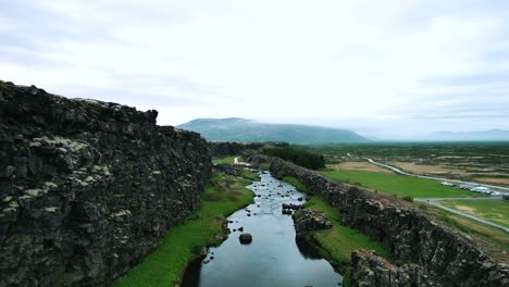 melted glacier river at thingvellir national park in rift valley, iceland, slow motion drone shot