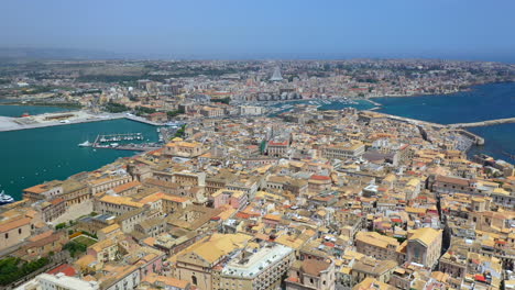 wide drone shot of syracuse coastline, historic city on the italian island of sicily