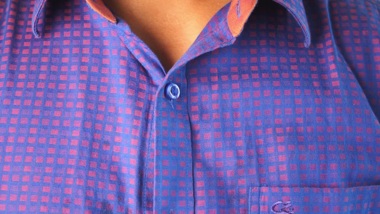 el hombre abotonando su camisa.