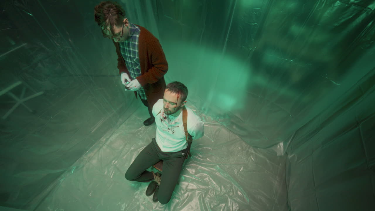 플라스틱으로 인 방에서 칼로 희생자를 위협하는 미치광이의 높은 각도