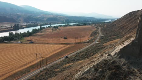 Hermosa-Vista-Aérea-Del-Camión-En-Una-Carretera-Entre-Una-Colina-Y-Campos