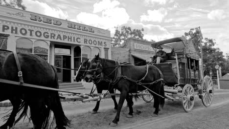 horse-drawn carriage passing through old western town