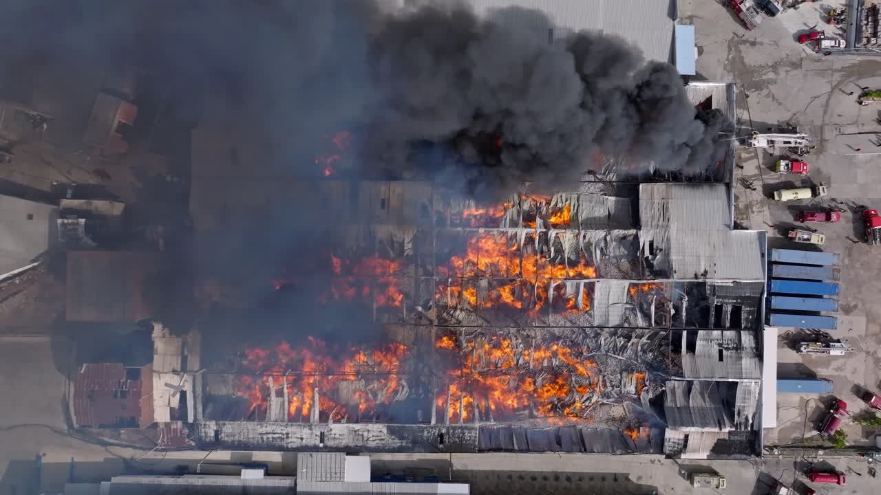 Massive Industrial Fire: Aerial View of Burning Building and Emergency Response