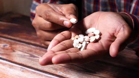 persona con pastillas en la mano