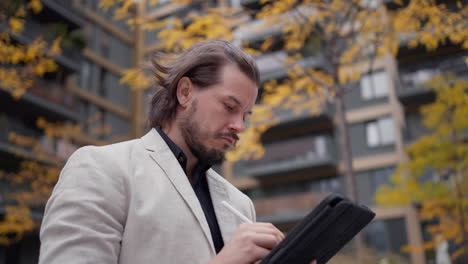 Close-up-handsome-businessman-using-his-tablet-computer