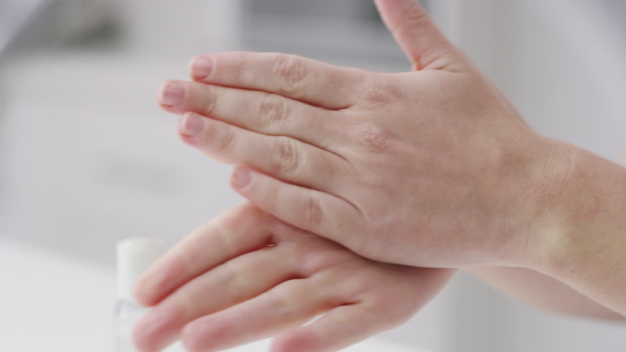 una mujer irreconocible desinfectando sus manos