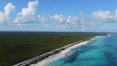 Panorámica-Aérea-De-La-Vasta-Jungla-En-La-Isla-De-Cozumel-Con-La-Hermosa-Costa-Azul-Turquesa-Del-Océano-En-México