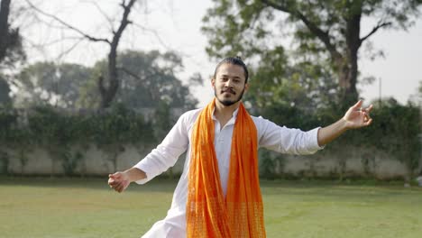 un bel homme indien dansant en plein air dans des vêtements traditionnels