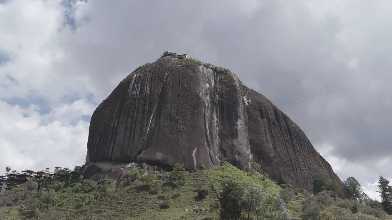 This giant granite rock formation stands majestically amid lush hills and winding lakes, with a staircase leading to the viewing platform at its summit