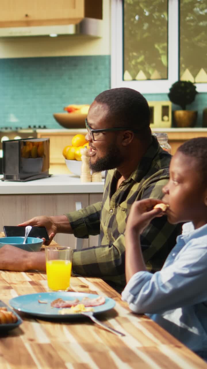 Vertical Video African American family serving breakfast together in a bright kitchen