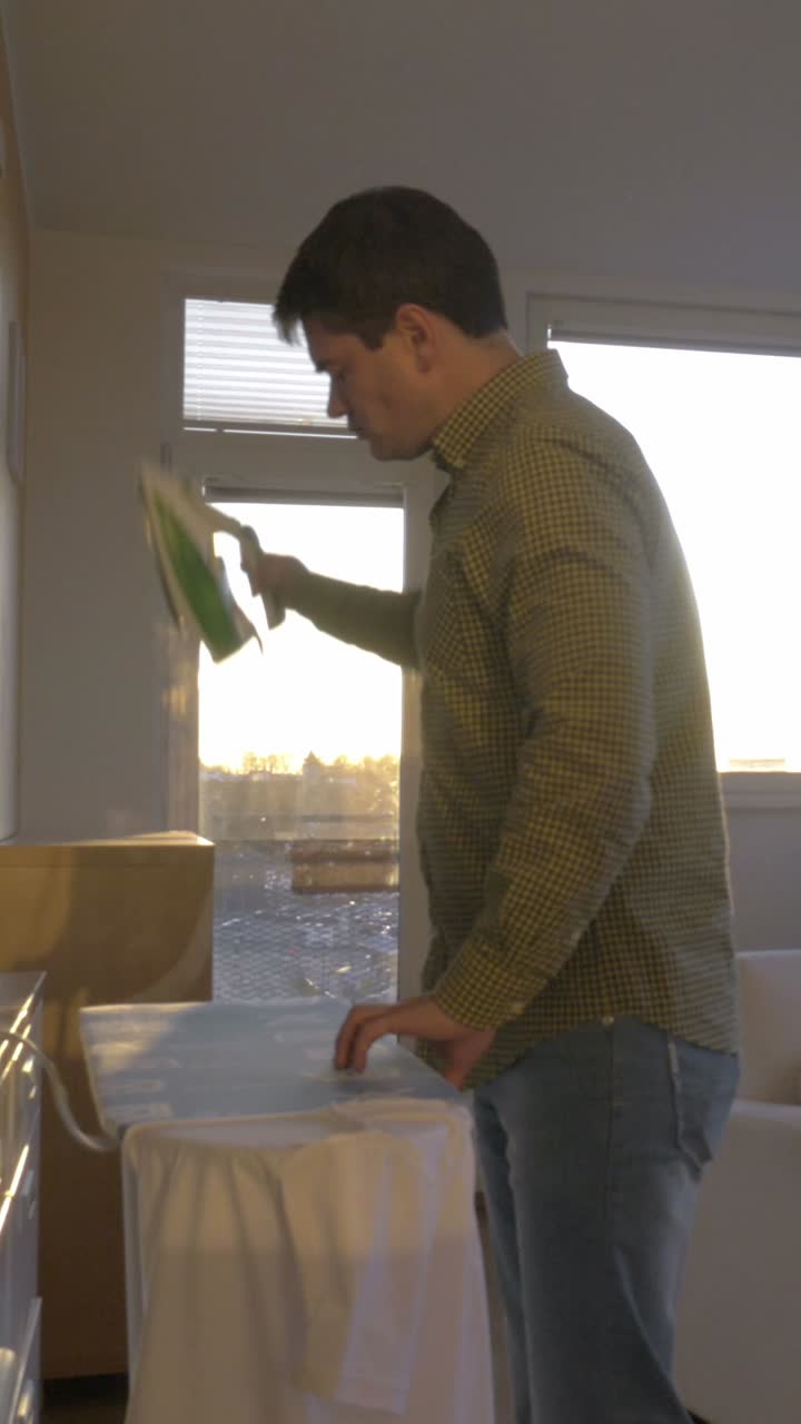 Man ironing a shirt at home