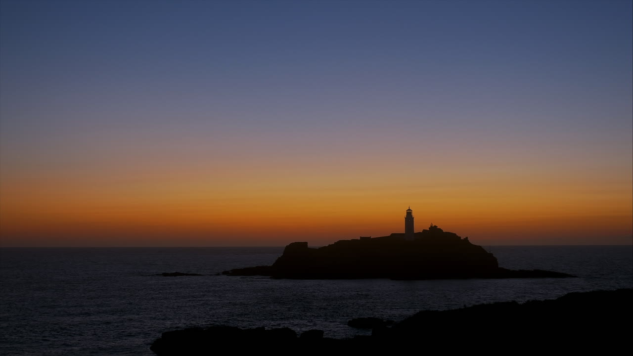 오렌지색, 황토색, 파란색이 있는 갓레비 등대에서 황금빛 따뜻한 일몰, 패닝 샷