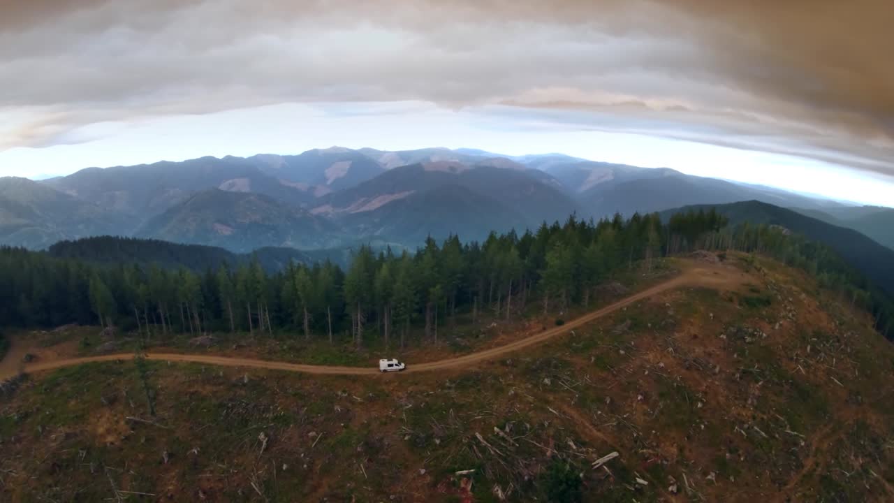 Camper van driving along a mountain ridgeline, aerial 59.94