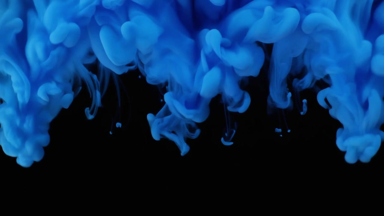 Inchiostro blu che cade e si avvolge nell'acqua su sfondo nero
