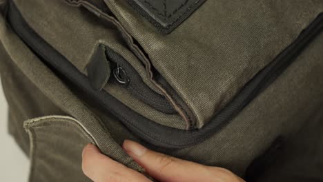 A-person-opening-a-zipper-on-a-canvas-bag-in-a-close-up-shot