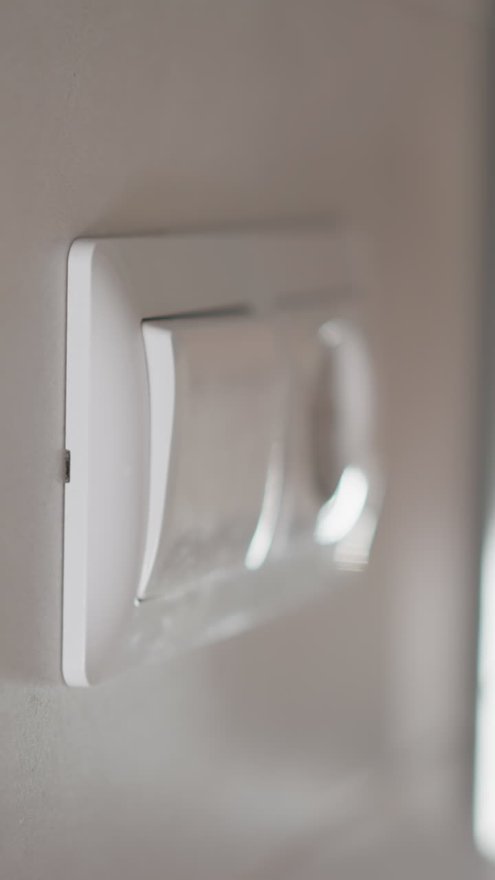 mano femenina con manicura presiona el botón apagando la luz en una habitación espaciosa. mano de mujer presiona el interruptor después de los procedimientos en el baño en cámara lenta