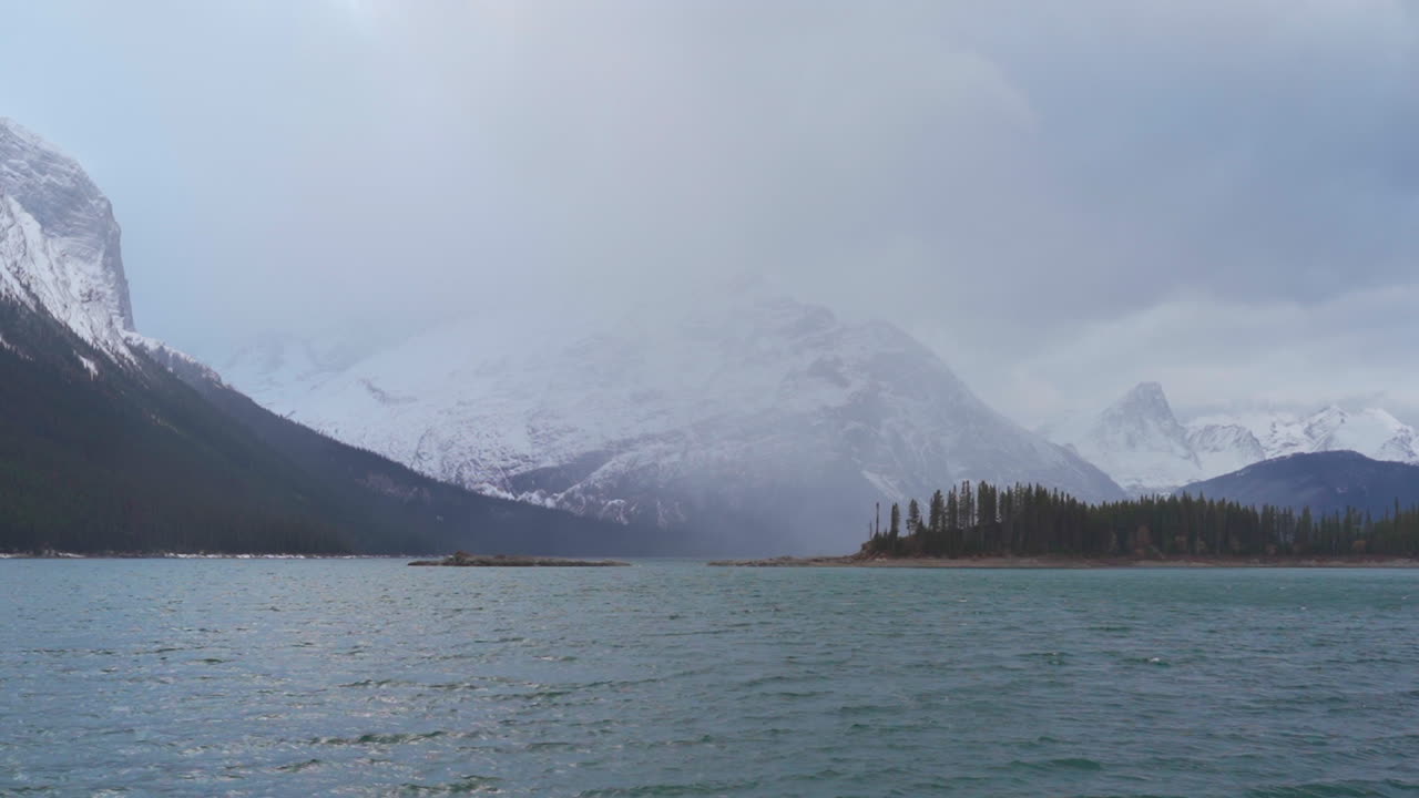 escena ventosa de montañas con un lago durante un día nublado