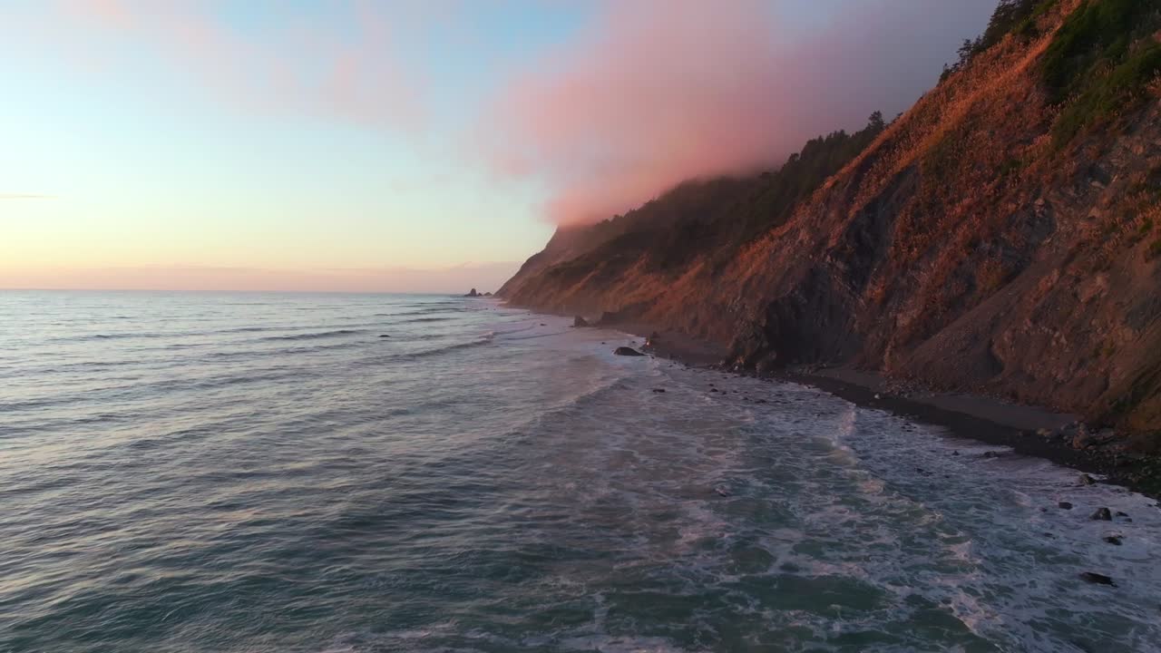 Northern California waves crashing bluffs cliffside mountain rocky rugged remote coastline aerial drone vibrant sunset USAL Beach Campground Sinkyone Wilderness surf swell forward motion