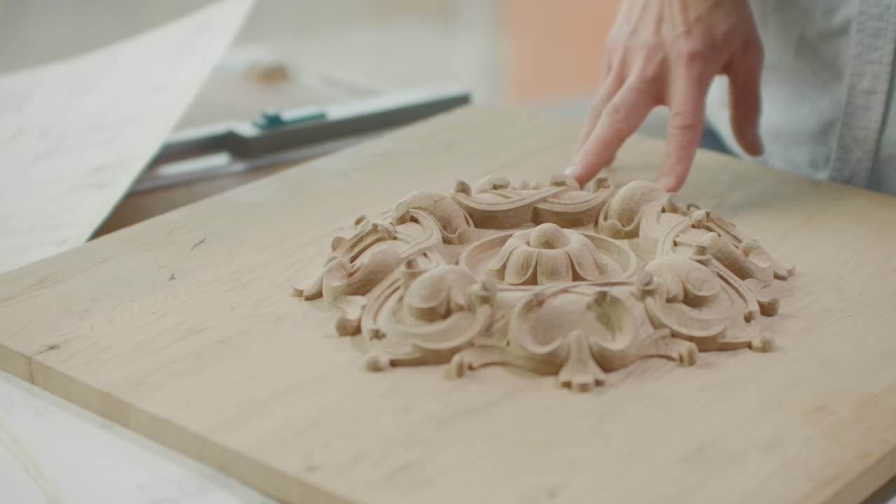 un arquitecto masculino mira dibujos y planos de edificios en una oficina de loft contra una gran ventana. el diseñador planea la fachada de los edificios. creando diseño de muebles