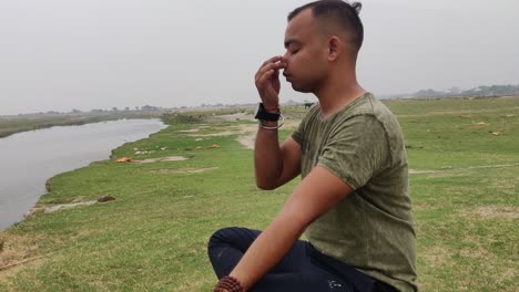 side profile of an asian boy practicing yoga and meditating sitting down in a lotus position