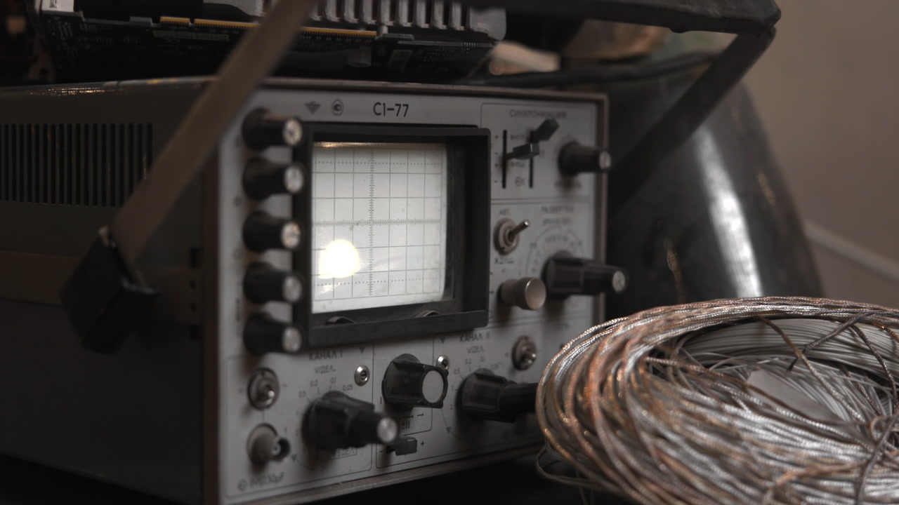 Signal Oscilloscope And Coiled Wire On Testing Bench, Glowing Trace And Control Knobs, Lab Repair Setting . Media