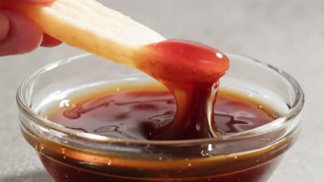 dipping french fries in sauce