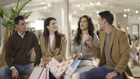 a group of friends or family members sitting and interacting in a shopping mall