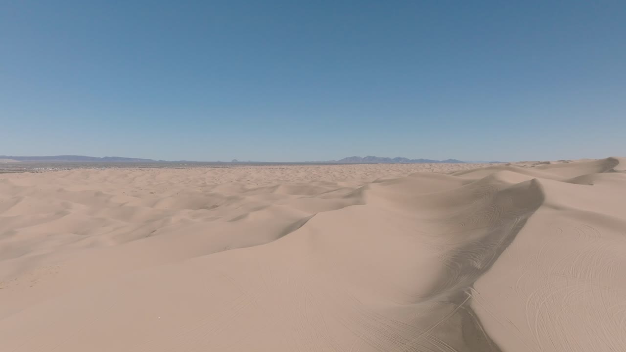 캘리포니아 남서부 사막에 있는 모래사막의 패닝 드론 샷, 푸른 하늘 앞에