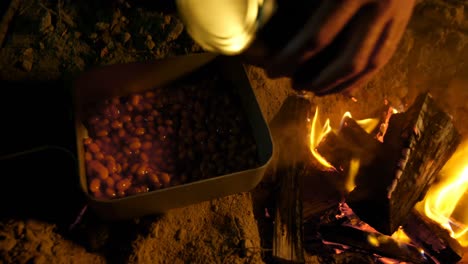 man cooking food on campfire in the forest 4k