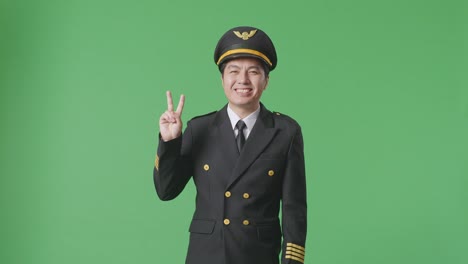 pilot in uniform with a v-sign