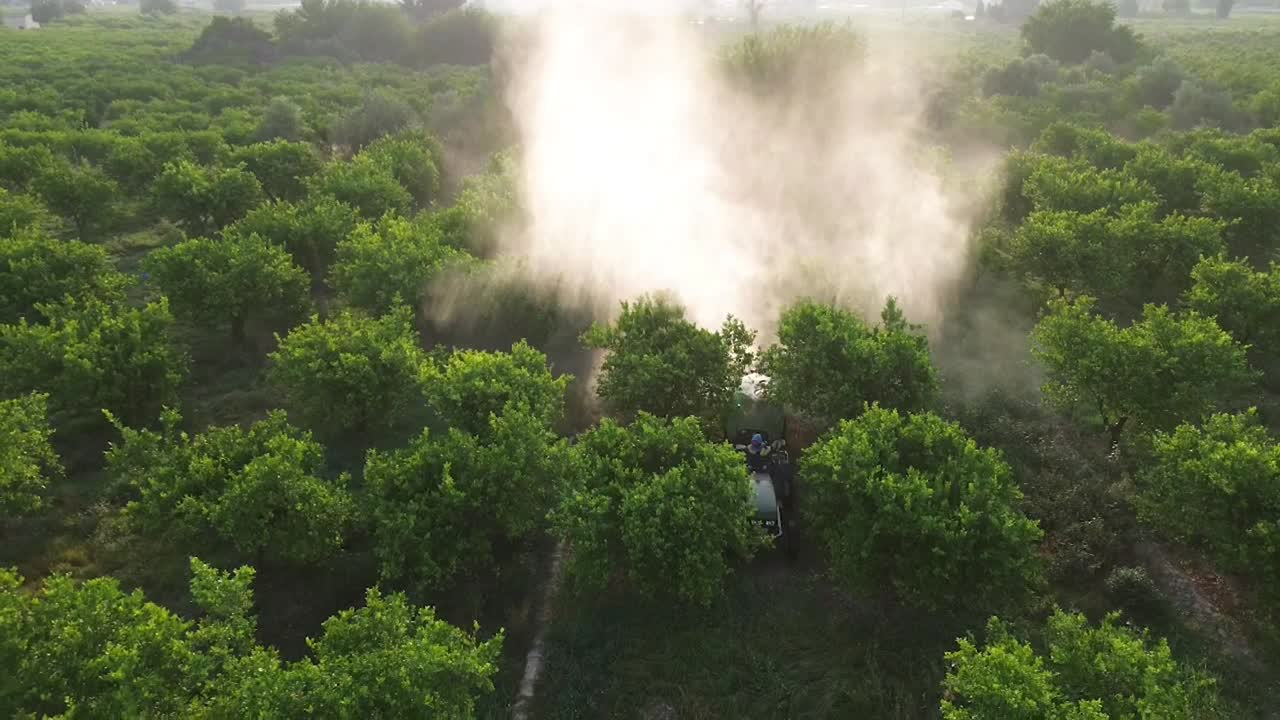 Tractor spraying pesticide drone aerial view, pesticides or insecticide spray on lettuce or iceberg field. Pesticides and insecticides on agricultural field in Spain