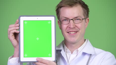 happy man doctor showing chroma key green screen digital tablet