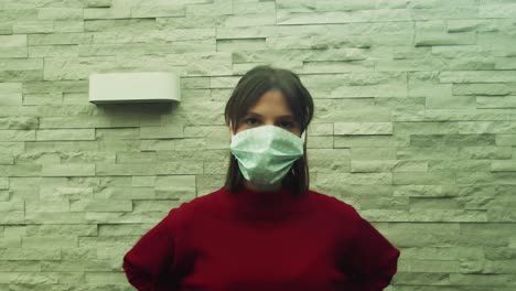 girl laughing and putting mask on with a neutral green background