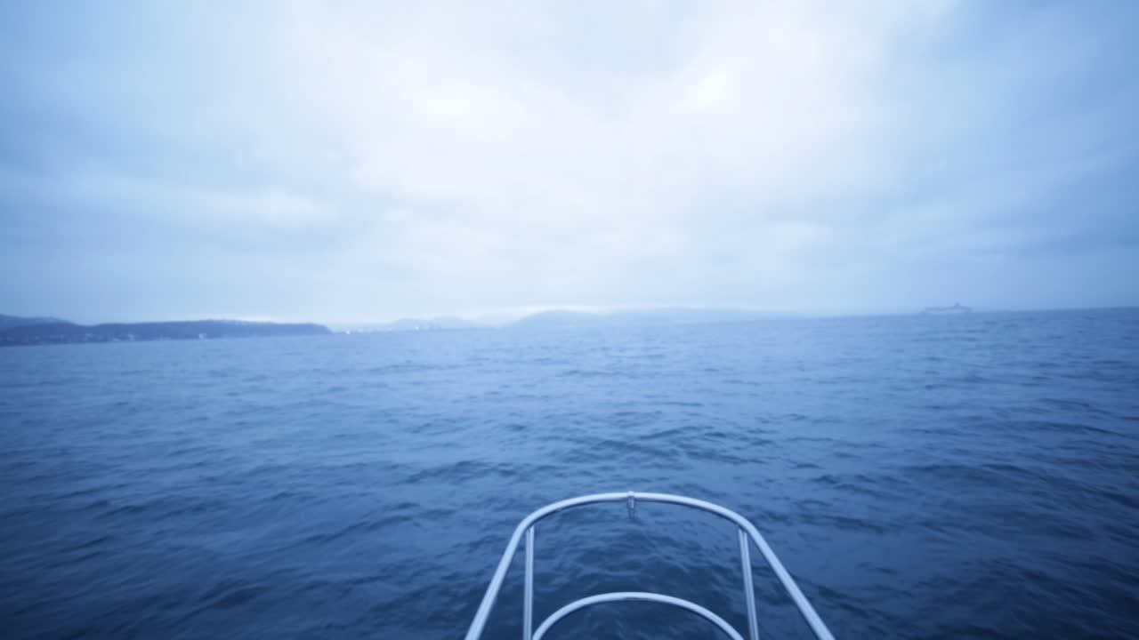 Der Blick nach vorne aus dem Cockpit eines Bootes mitten auf dem Ozean an einem bewölkten Tag.