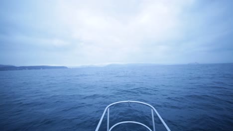 the front view from the cock pit of a boat in the middle of the ocean during a cloudy day