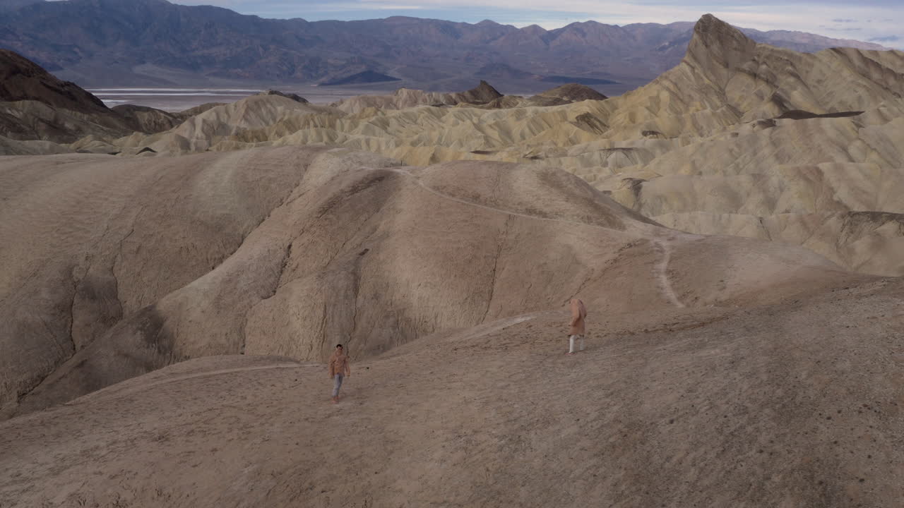 Two People Explore Vast Arid Desert Mountains