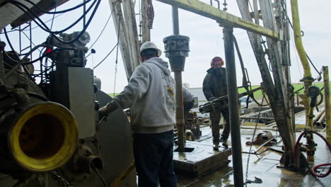 industrious men working at the drilling site. workers maintaining the boring equipment at onshore pipeline.