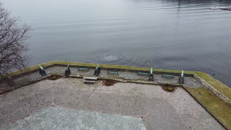 Old-canons-on-square-outside-Kristiansand-fortress-in-southern-Norway---Aerial-from-above-fortress-looking-down-at-canons-with-north-sea-in-front